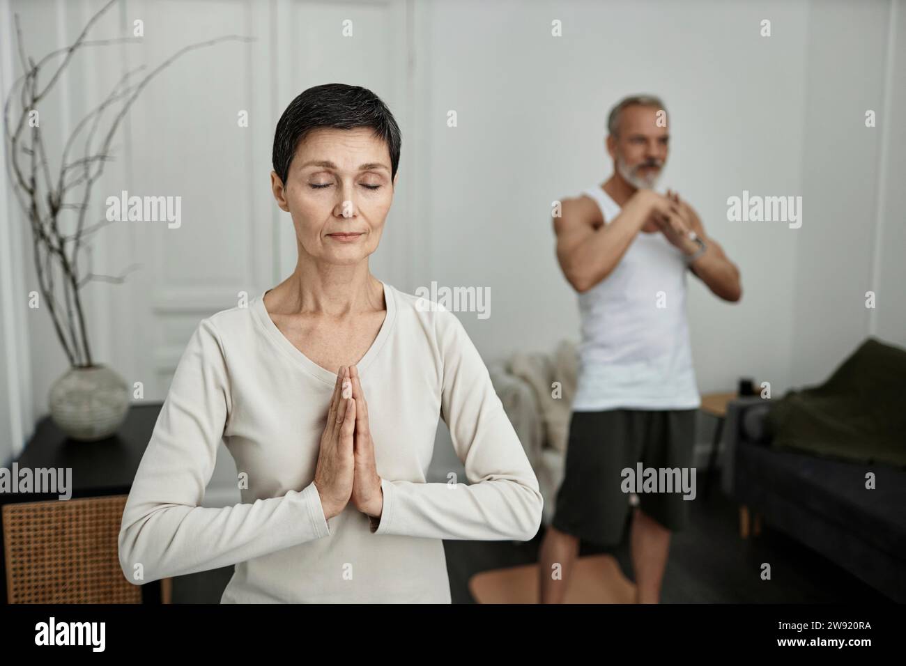 Coppia che fa esercizi di yoga a casa la mattina Foto Stock