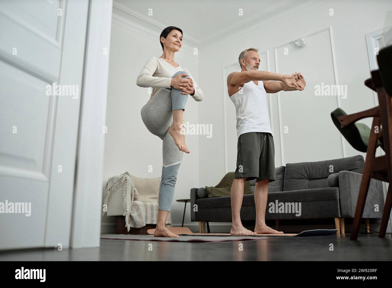 Coppia che fa esercizi di stretching la mattina a casa Foto Stock