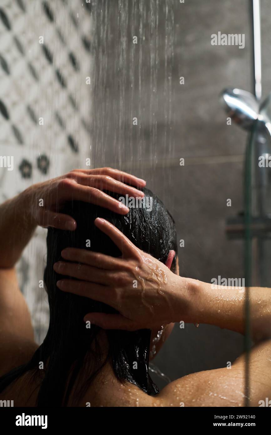 Donna che lava i capelli e fa il bagno a casa Foto Stock