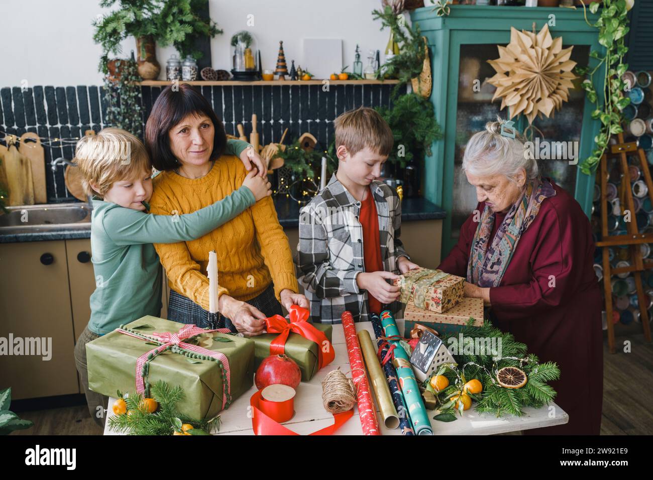 Famiglia che si aiuta a vicenda a portare regali di Natale a casa Foto Stock