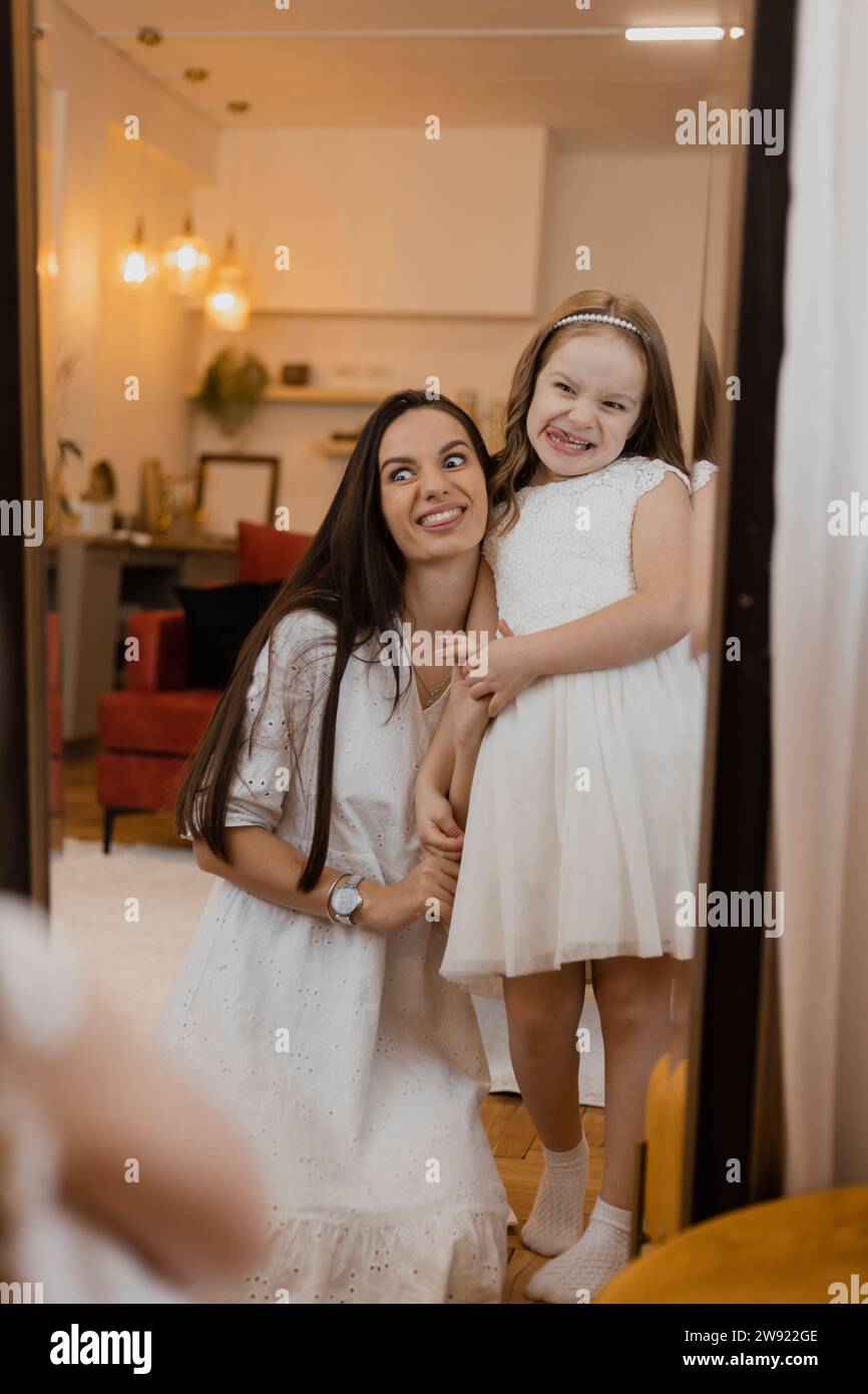 Madre e figlia felici che fanno facce a specchio Foto Stock