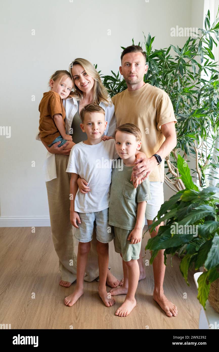 Famiglia sorridente con bambini in salotto a casa Foto Stock