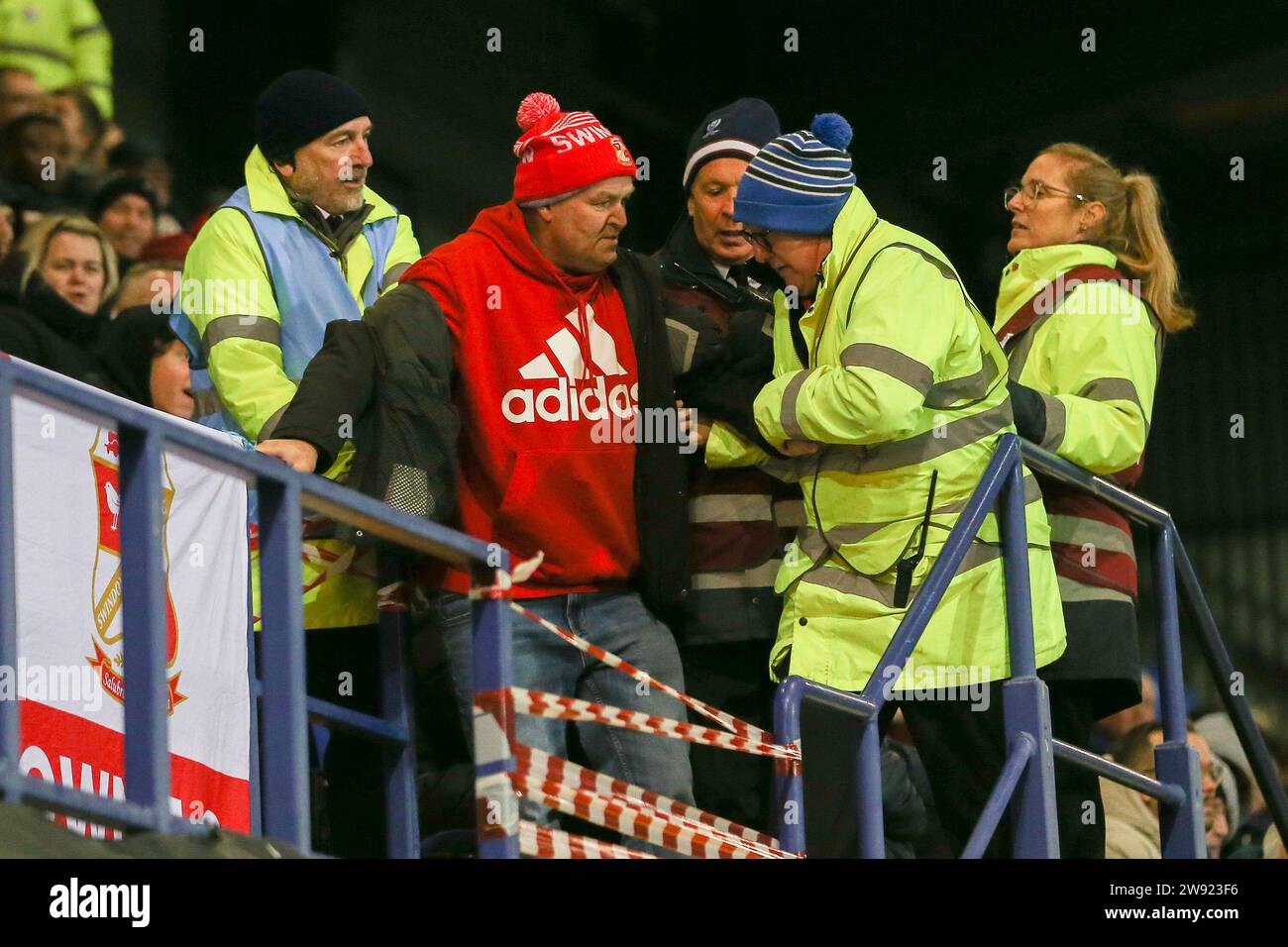 Birkenhead, Regno Unito. 23 dicembre 2023. Un fan di Swindon Town lotta con gli amministratori mentre viene rimosso da terra. EFL Skybet Football League Two match, Tranmere Rovers contro Swindon Town a Prenton Park, Birkenhead, Wirral sabato 23 dicembre 2023. Questa immagine può essere utilizzata solo per scopi editoriali. Solo per uso editoriale, .pic di Chris Stading/ Credit: Andrew Orchard fotografia sportiva/Alamy Live News Foto Stock