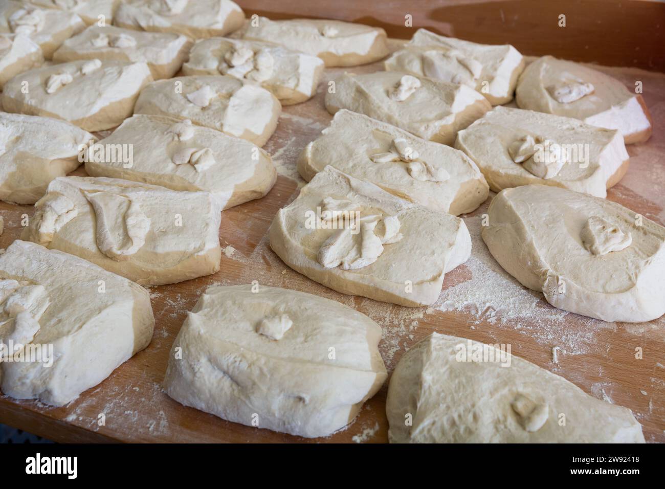 Pasta cruda divisa in pezzi porzionati sul piano di lavoro del panettiere Foto Stock