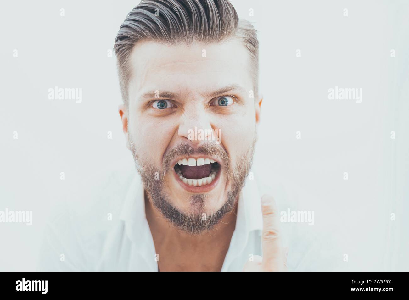L'uomo elegante dal look pazzo guarda la fotocamera. Il concetto di soppressione, stimolazione, motivazione per il successo aziendale. Supporti misti Foto Stock