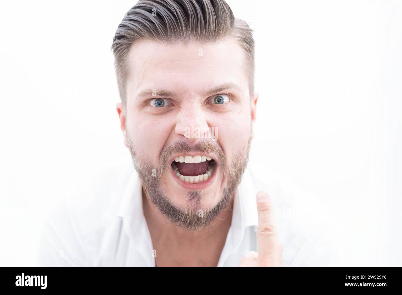 L'uomo elegante dal look pazzo guarda la fotocamera. Il concetto di soppressione, stimolazione, motivazione per il successo aziendale. Supporti misti Foto Stock