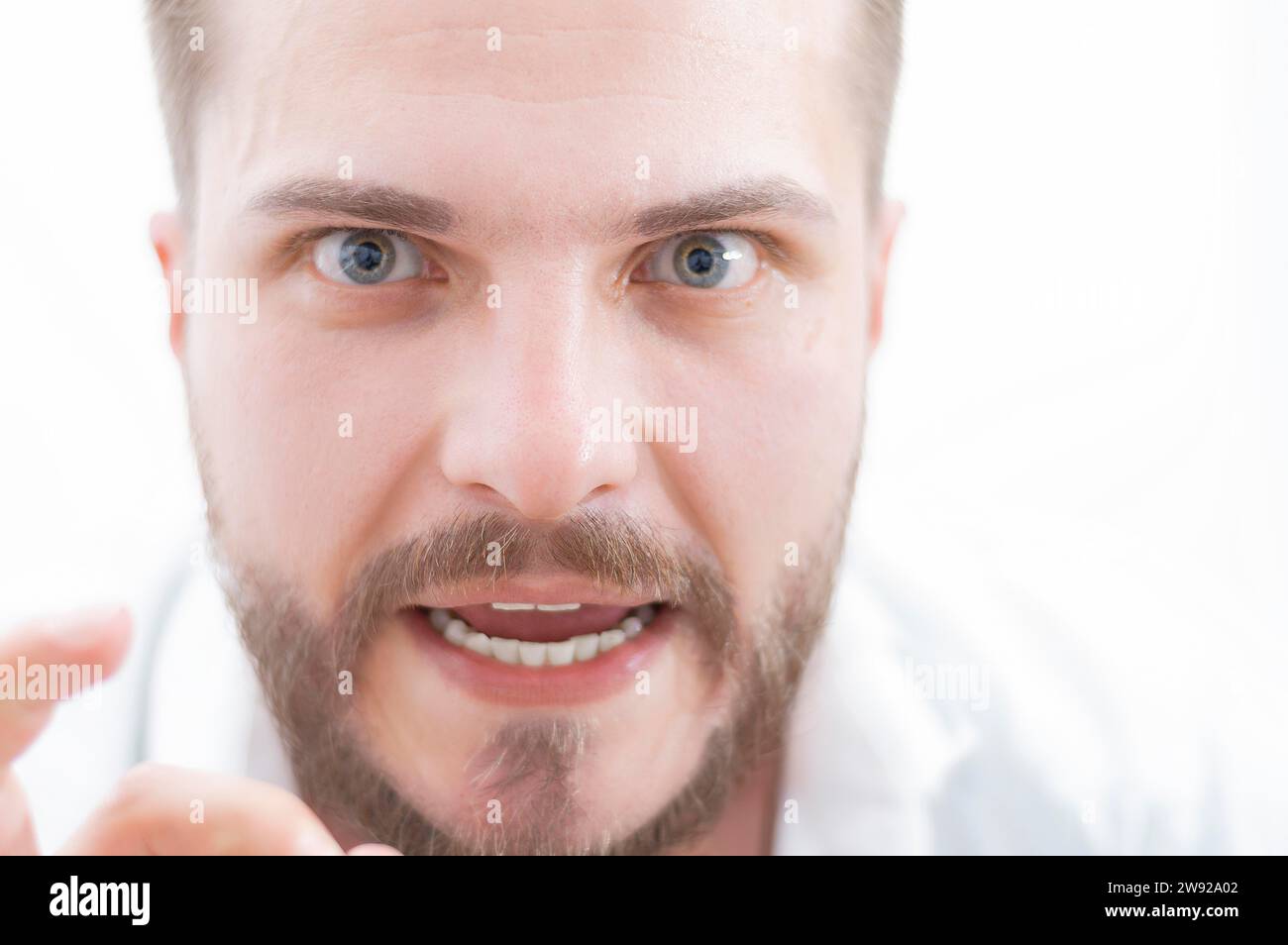 L'uomo elegante dal look pazzo guarda la fotocamera. Il concetto di soppressione, stimolazione, motivazione per il successo aziendale. Supporti misti Foto Stock