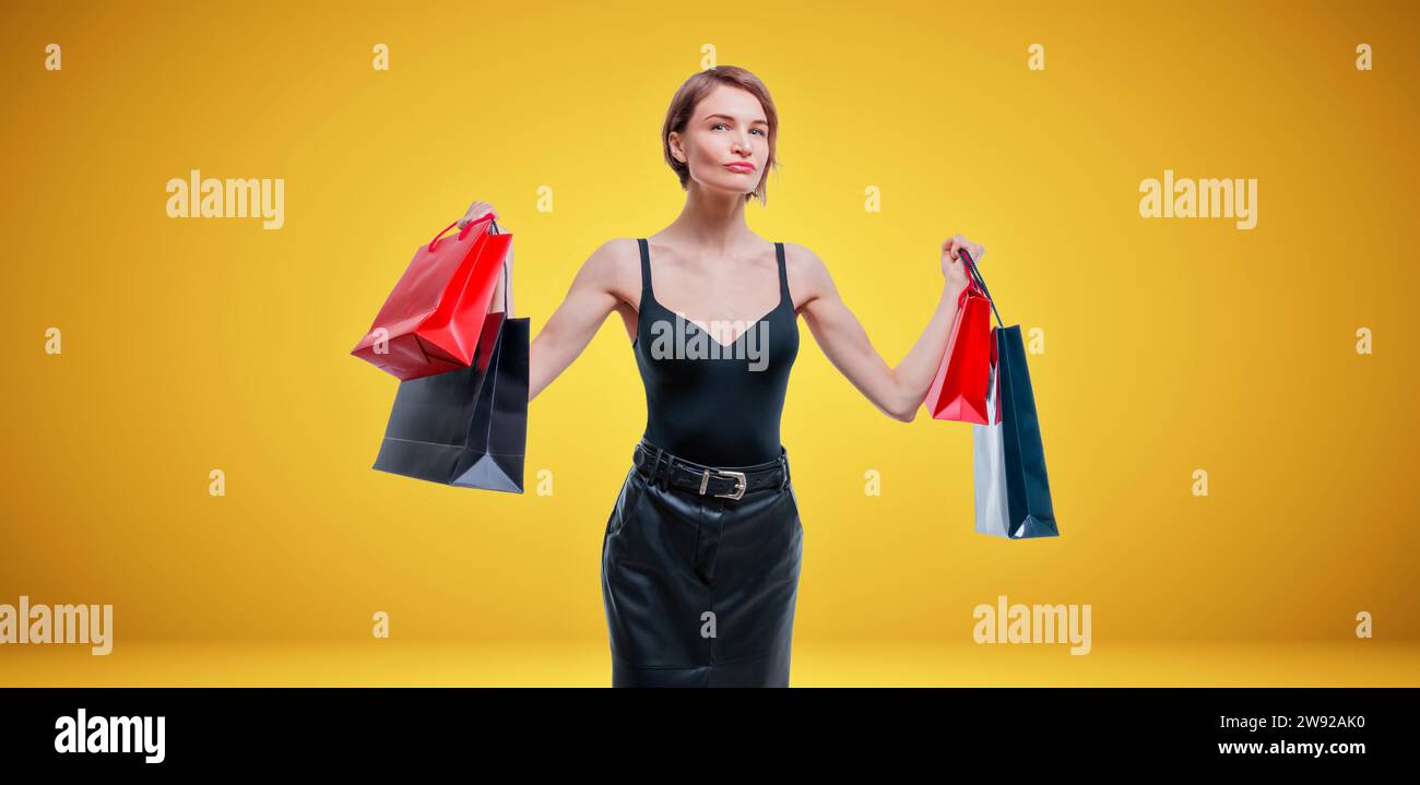 Donna d'affari che posa in studio con pacchetti con regali. Concetto di giornata internazionale delle donne. San Valentino. Supporti misti Foto Stock