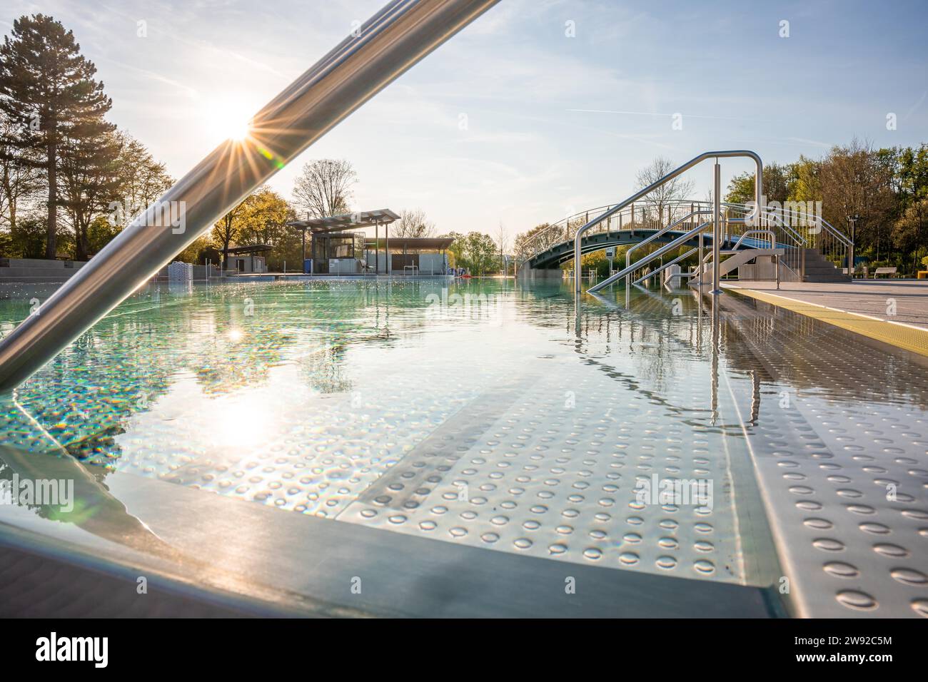 Sciame di raggi del sole su una tranquilla piscina dietro ringhiere in acciaio inossidabile, piscina all'aperto Calw, Stammheim della Calw Public Utility Company, Black Foto Stock