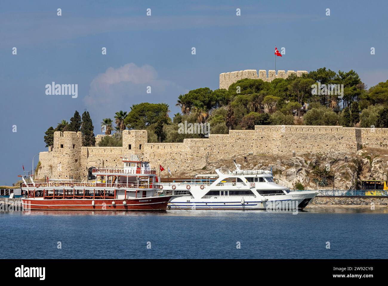 Escursione in barca e yacht sulla strada rialzata per Pigeon Island nella baia di Kusadasi. Una fortezza genovese torreggia sulla cima dell'isola, Kusadasi Foto Stock