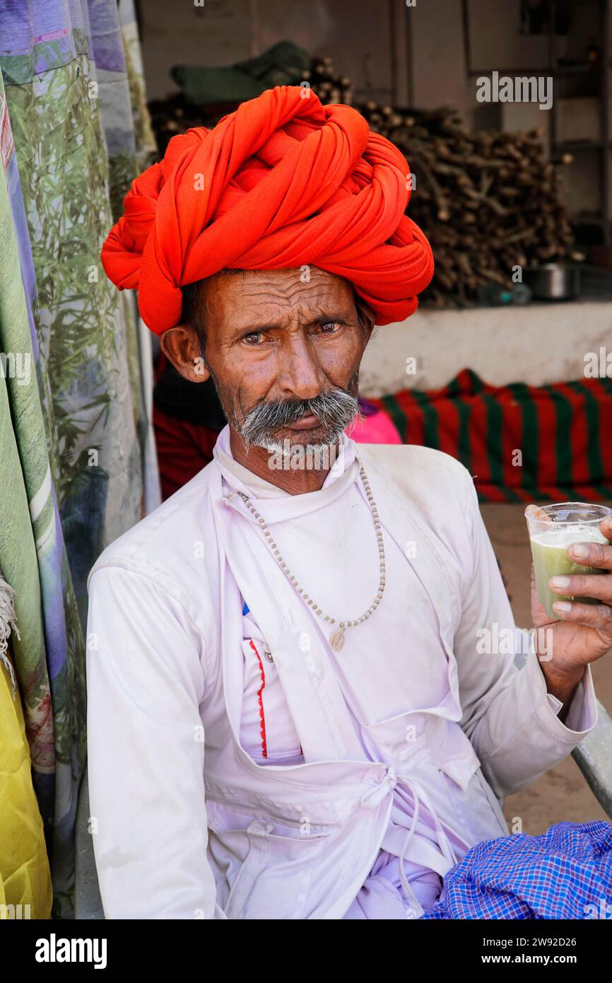 Uomo indiano che beve succo di canna da zucchero, mercato dei cammelli, Pushkar Mela, Pushkar, Rajasthan, India Foto Stock