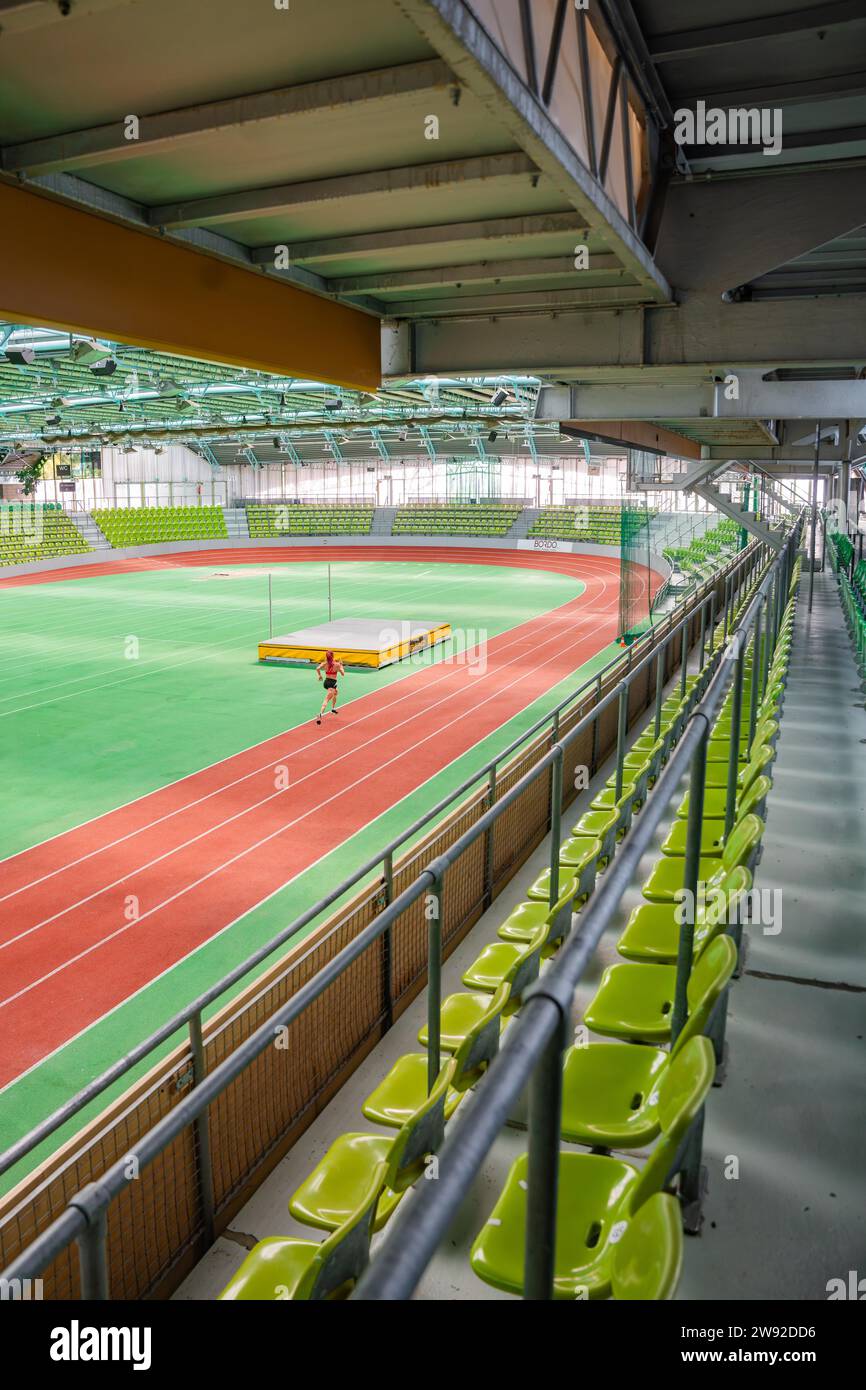 Allenamento degli atleti sulla pista da corsa in uno stadio con file verdi di sedili, Glaspalast Sindelfingen, Germania Foto Stock