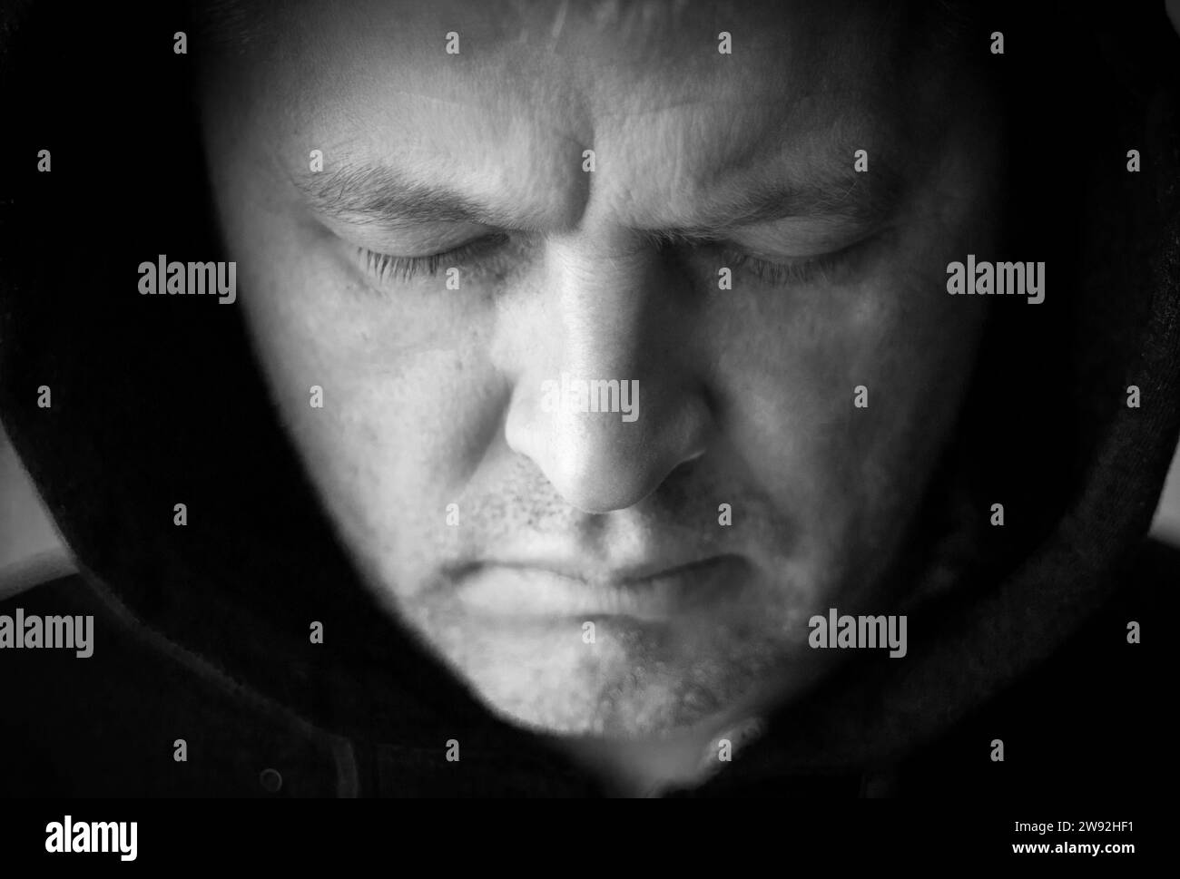 L'uomo sembrava un hacker in un cofano che guardava lo schermo. Foto Stock L'uomo sembrava un hacker in un cofano che guardava lo schermo. Foto Stock