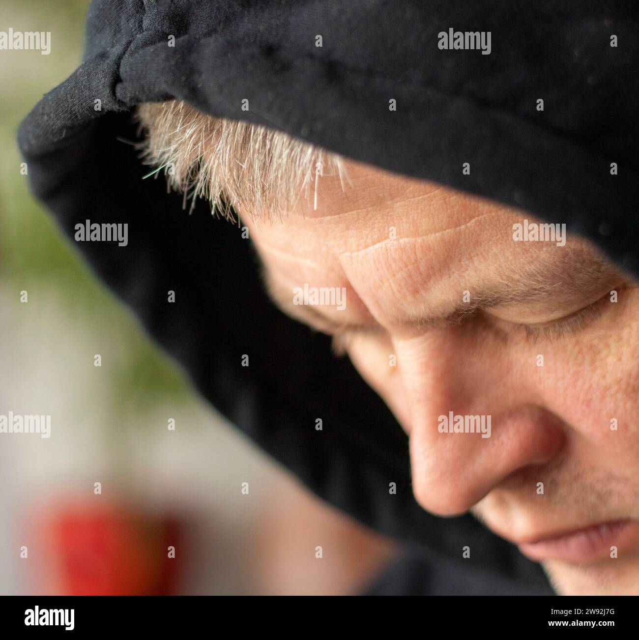 L'uomo sembrava un hacker in un cofano che guardava lo schermo. Foto Stock L'uomo sembrava un hacker in un cofano che guardava lo schermo. Foto Stock