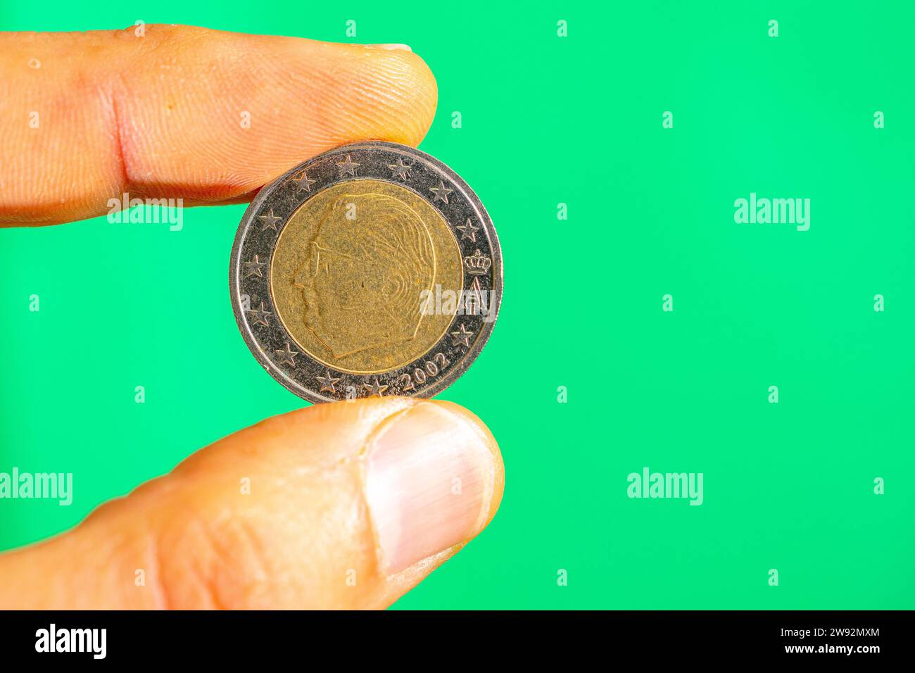 corona di monete da 50 centesimi di euro tra pollice e indice. Foto Stock