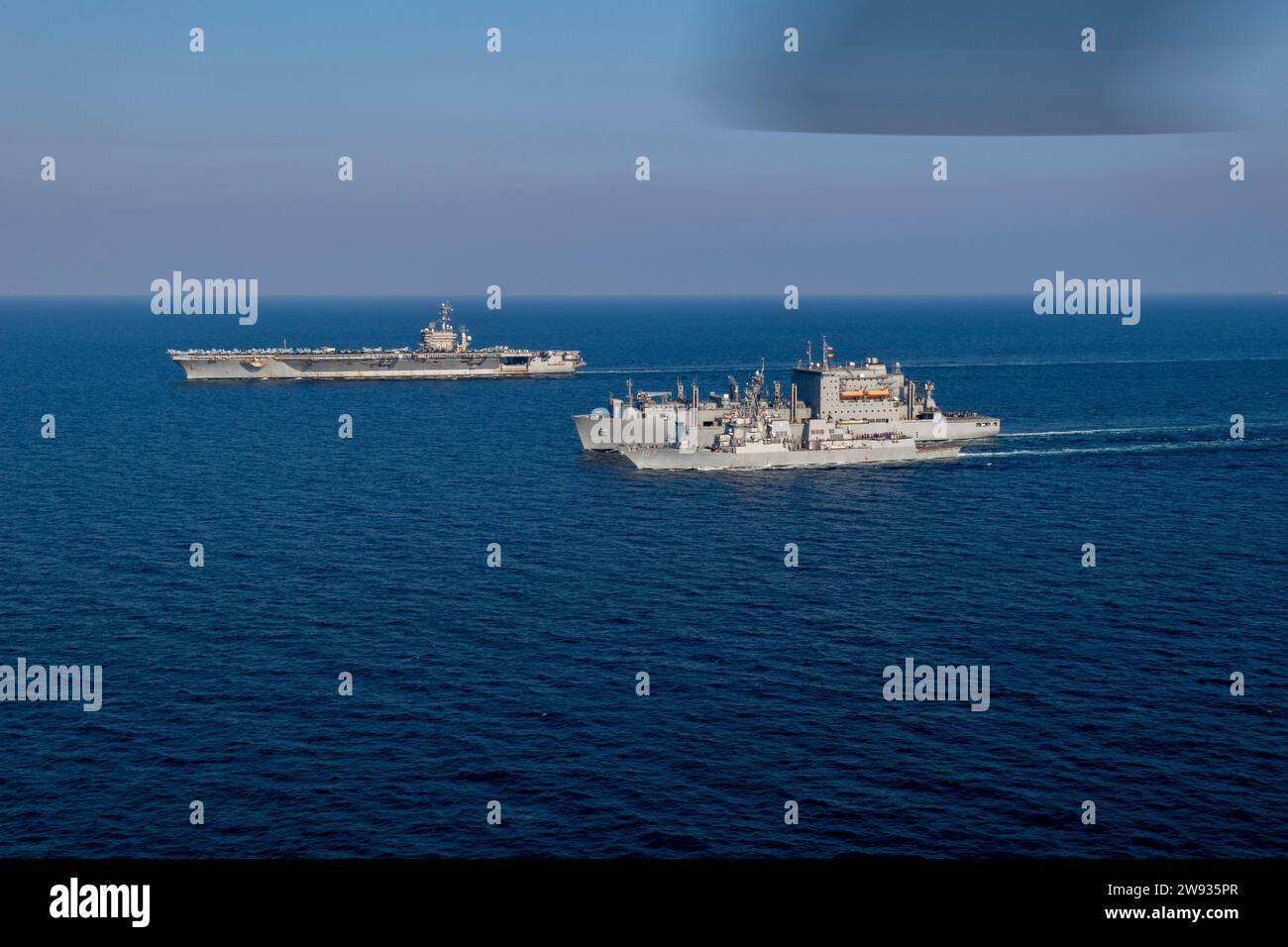 La portaerei USS Dwight D. Eisenhower (CVN 69), la nave da carico secco USNS Alan Shepard (T-AKE 3) e il cacciatorpediniere missilistico guidato USS Gravely (DDG 107) conducono un rifornimento in mare nel Golfo Arabico, 8 dicembre 2023. Il Dwight D. Eisenhower Carrier Strike Group è schierato nell'area operativa della 5th Fleet degli Stati Uniti per sostenere la sicurezza marittima e la stabilità nella regione del Medio Oriente. (Foto della Marina degli Stati Uniti di Mass Communication Specialist 2nd Class Merissa Daley) Foto Stock