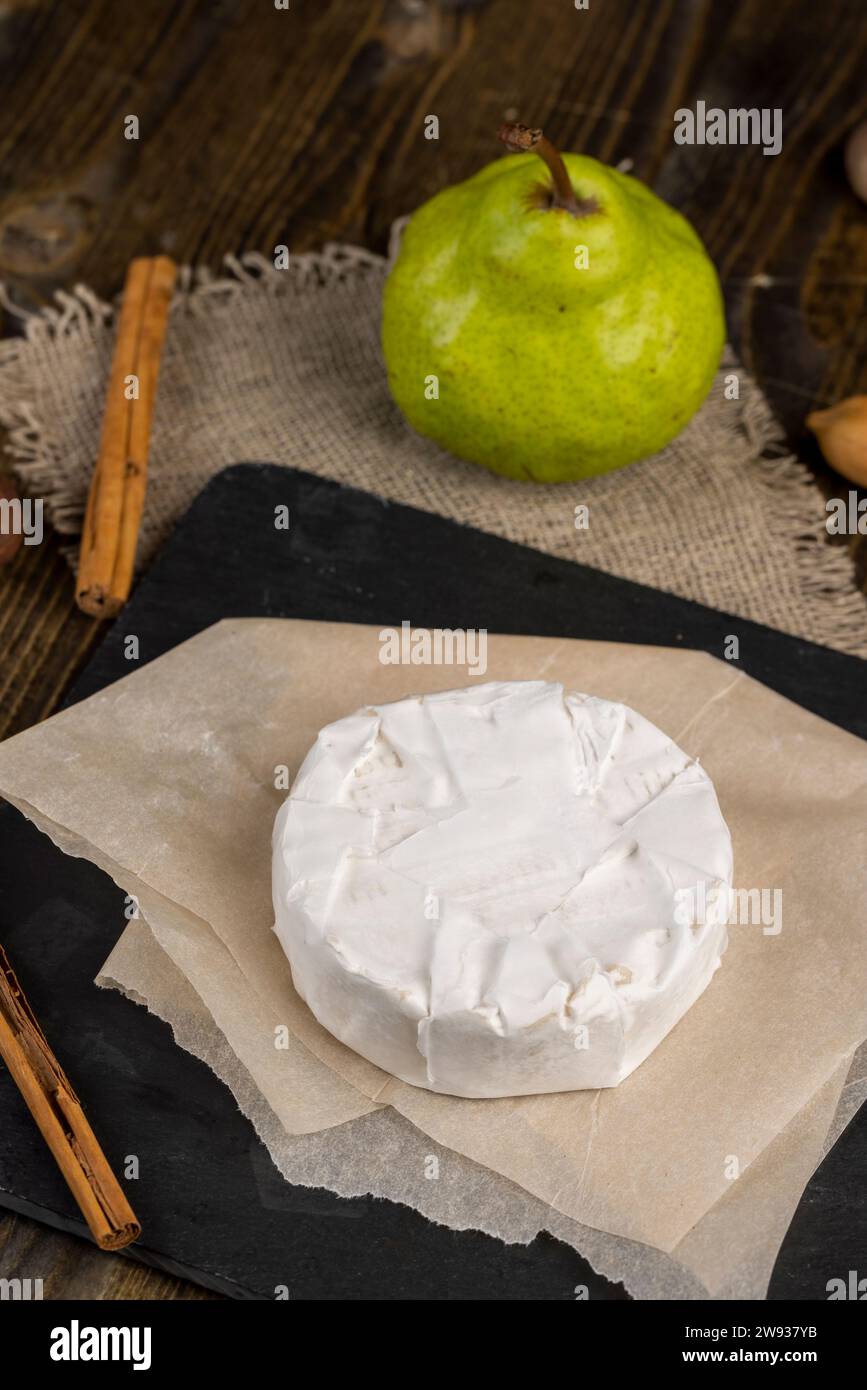 formaggio rotondo bianco con muffa sul tavolo, formaggio fresco morbido con muffa bianca nobile che si può mangiare Foto Stock