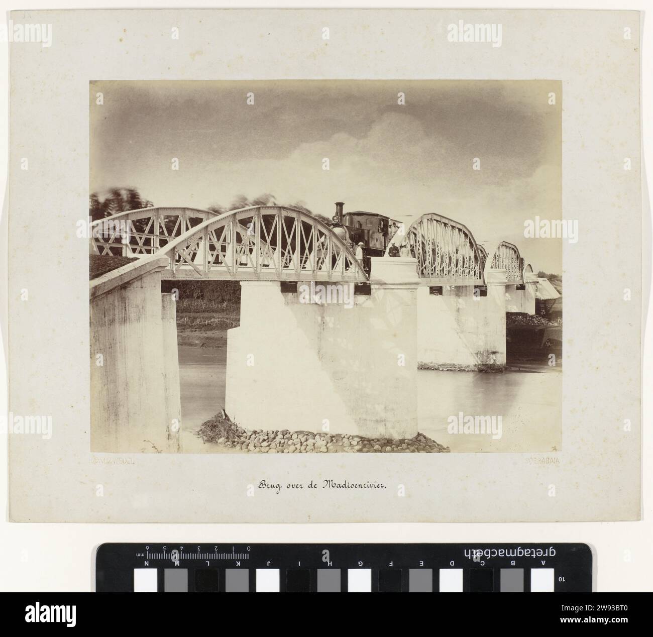 Utilizza MadioenRivier, Herman Salzwedel, 1880 - 1888 fotografa il ponte Spoor sul fiume Madiun (Madioen), un treno sul ponte e alcuni uomini in piedi. Parte di un gruppo di 62 foto in una scatola con l'iscrizione "Staatsspoorwegen on Java" del 1888. Surabaya Photographic Support albumen print Madiun Foto Stock