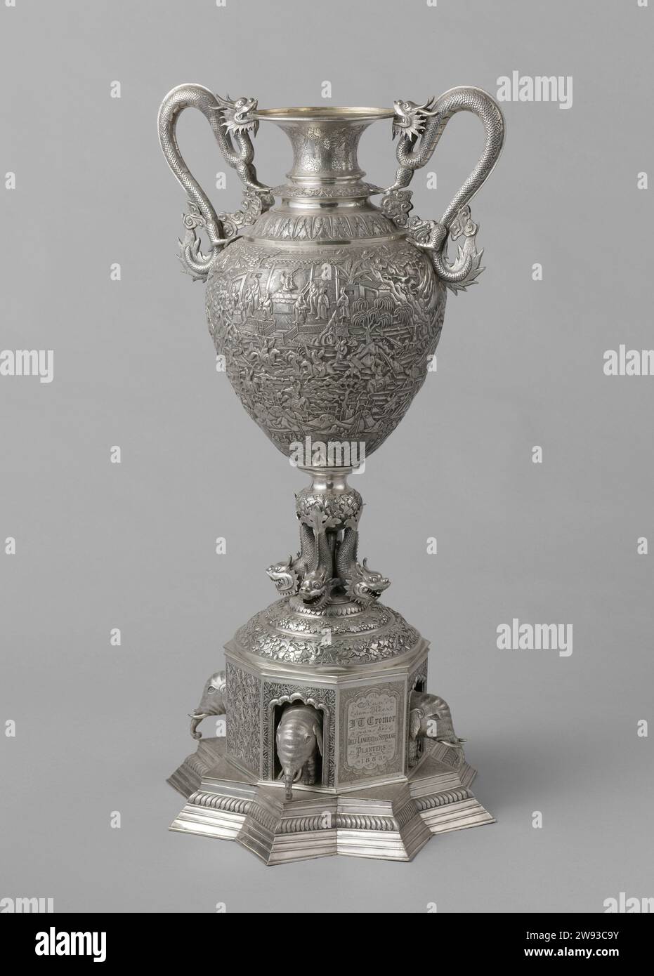 Centrotavola da tavolo in argento con scene cinesi, anonimo, c. 1880 - 1883 pezzo da tavolo in argento riccamente decorato nel 1883 offerto al signor J.th. Cremer. Piedistallo a forma di stella con 8 punti su cui una parte a 8 angoli con 4 elefanti e iscrizione. Tra il vaso e il piedistallo 4, con pesci. Sulle esibizioni di vasi della vita cinese. Due maniglie sotto forma di draghi. Sopra il coperchio sciolto coronato da un mandarino cinese. Cina argento (metallo) Cina. Sumatra Foto Stock