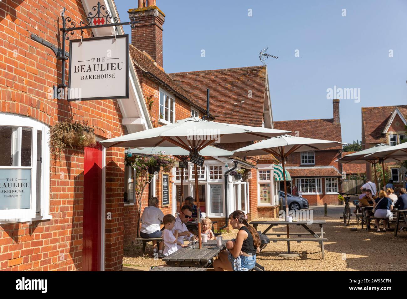 Villaggio Beaulieu nella New Forest e la casa del forno e le sale da tè con persone sedute all'aperto in una calda giornata di sole, Hampshire, Inghilterra, Regno Unito, 2023 Foto Stock