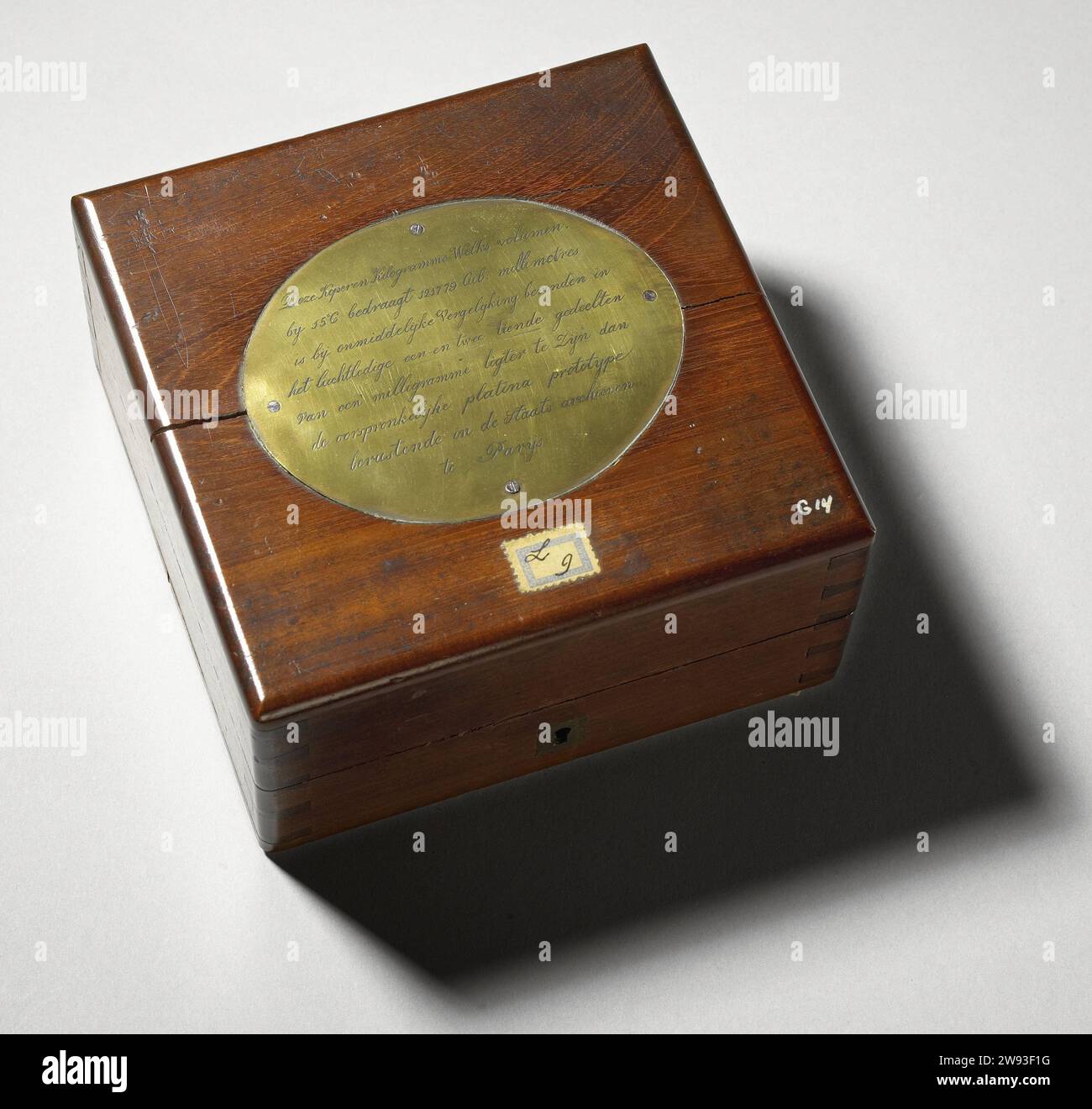 Peso di 1 kg in scatola, anonimo, peso 1839. Cilindro circolare dritto torace in ottone, peso di 1 kg, in una scatola di mogano dotata di serratura. Sul coperchio, una piastra ovale gialla con perdite su cui è riportata l'iscrizione. La scatola è coperta di velluto rosso all'interno, mentre il peso è coperto da un berretto di velluto rosso. Etichetta Kistje v.z.v. gewicht: ottone (lega). kist: mogano (legno). kist: velluto (tessuto). kist: Rame (metallo) Paesi Bassi. Parigi Foto Stock