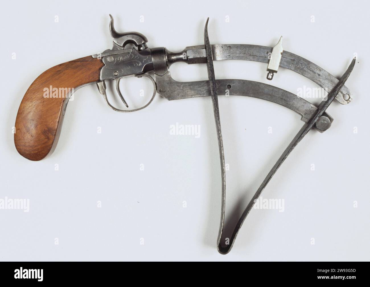 Collimetro a pistola, anonimo, c. 1825 - c. 1875 pistola di prova Buskruit (misuratore di potenza), percussione, con due archi di ferro, il cui arco superiore è lo strumento di misurazione. Gli archi sono fissati a una forca di ferro. Sopra la piastra di bloccaggio un gallo in ferro e sotto la piastra di bloccaggio una staffa per trattore in ferro con trattore, la piastra di bloccaggio è incisa con un motivo vegetale. Il matraccio è completamente in legno ed è fissato alla serratura con una vite. La pistola è dragata da un fosso dietro la caserma Alexander nella slot Europa occidentale dell'Aia: Ferro (metallo). Kolf: Incisione del legno (materiale vegetale) Paesi Bassi Foto Stock