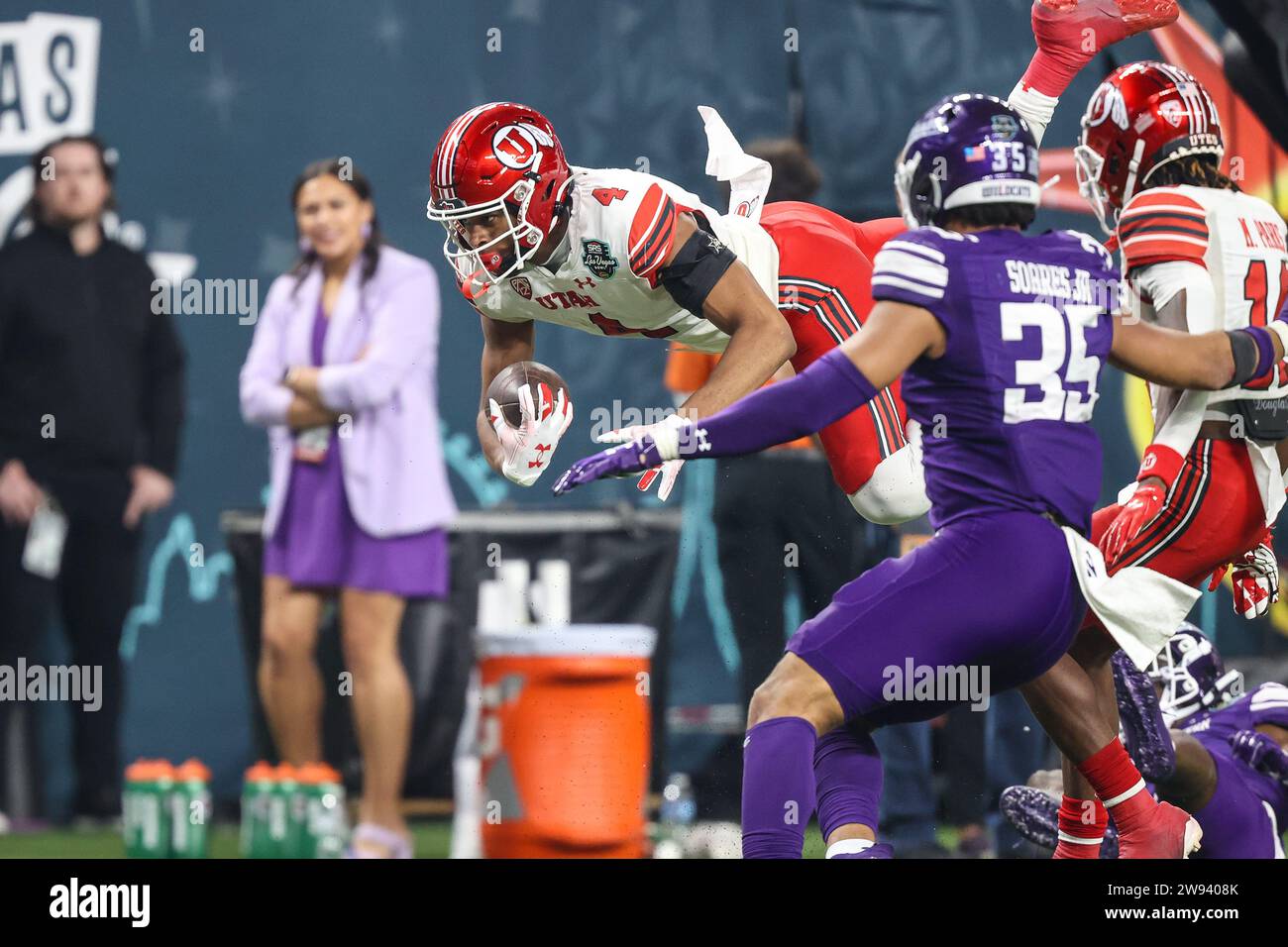 Las Vegas, Nevada, USA. 23 dicembre 2023. Il wide receiver degli Utah Utes Munir McClain (4) si tuffa su un difensore durante il secondo tempo dell'SRS Distribution Las Vegas Bowl con gli Utah Utes e i Northwestern Wildcats all'Allegiant Stadium di Las Vegas, Nevada. Christopher Trim/CSM/Alamy Live News Foto Stock