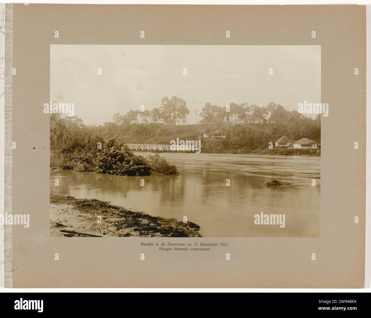 Bandjir nell'Enimrivier il 15 dicembre 1921. Livello dell'acqua molto conosciuto, 1921 fotografa High Water (Bandjir) nel River Air Enim il 15 dicembre 1921, a distanza il ponte ferroviario, alcuni edifici sul Oever dall'altro lato. Parte dell'album fotografico a foglia libera offerto dallo staff delle miniere di carbone Boekit-Asam a Sumatra al direttore dell'ingegnere di separazione H. Tromp il 7 gennaio 1922. Supporto fotografico Boekit-asam stampa argento gelatina Sumatra. Boekit-Asam Foto Stock