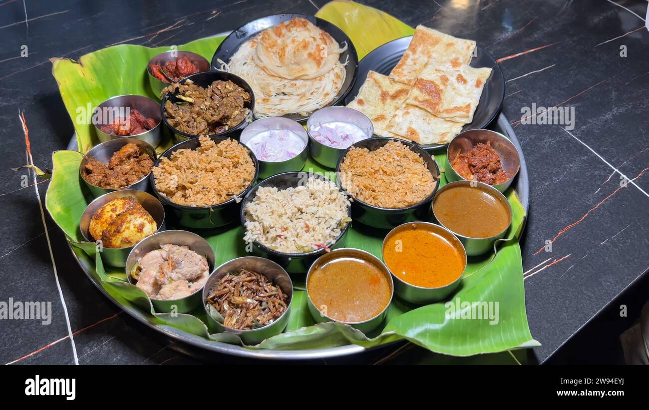 Assapora un Maharaja Thali a Coimbatore, con curry non vegetale, riso, curry vegetale, patate alla griglia speziate, curry di gamberi e montone, sottaceti, raita, due naan Foto Stock