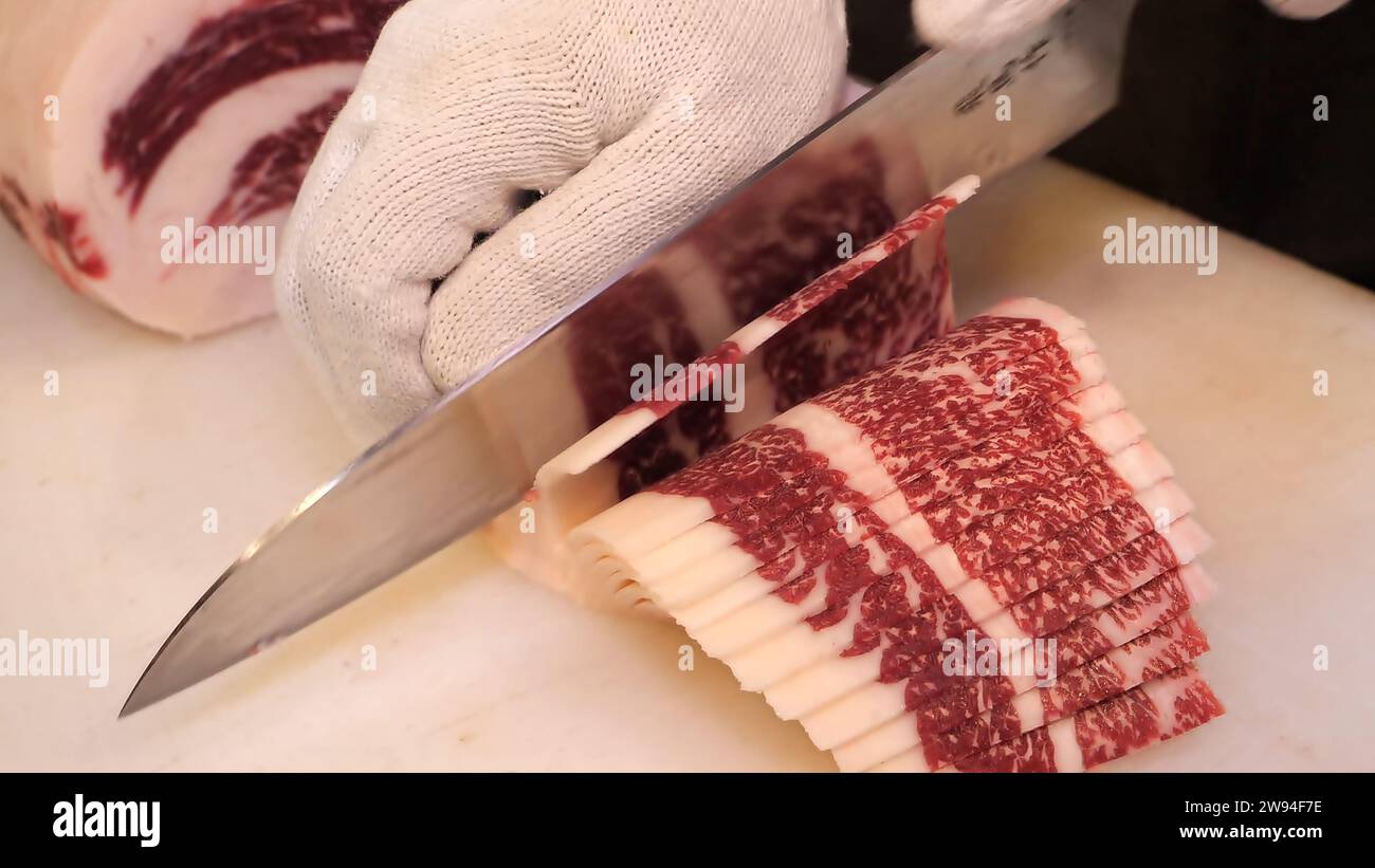 Tagli di manzo Premium - lo chef esperto intaglierà tagli di manzo di alta qualità con precisione. L'eccellenza culinaria incontra la precisione in questa splendida vetrina di blocchi di manzo Foto Stock