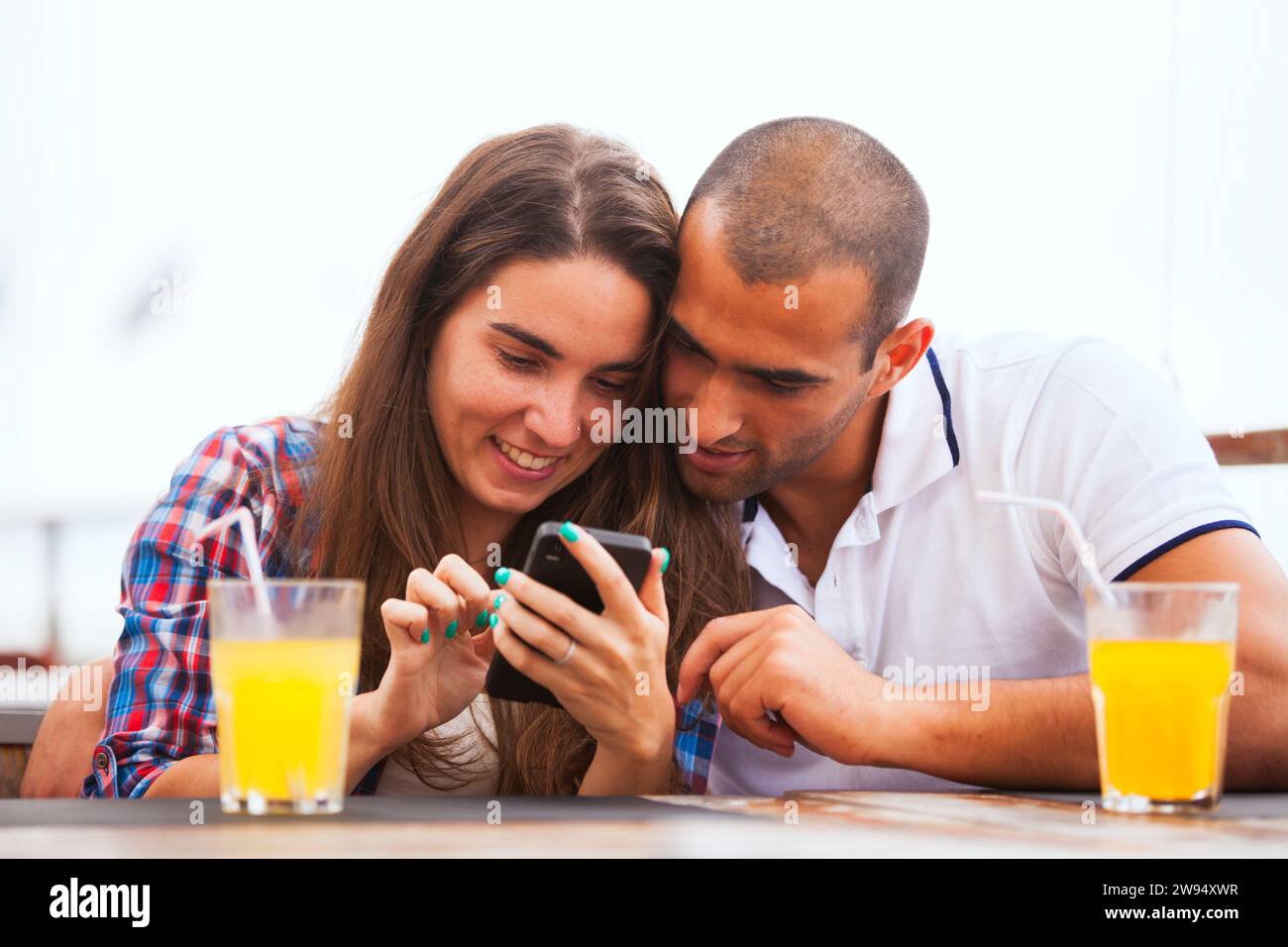 Coppia che guarda uno smartphone al bar Foto Stock