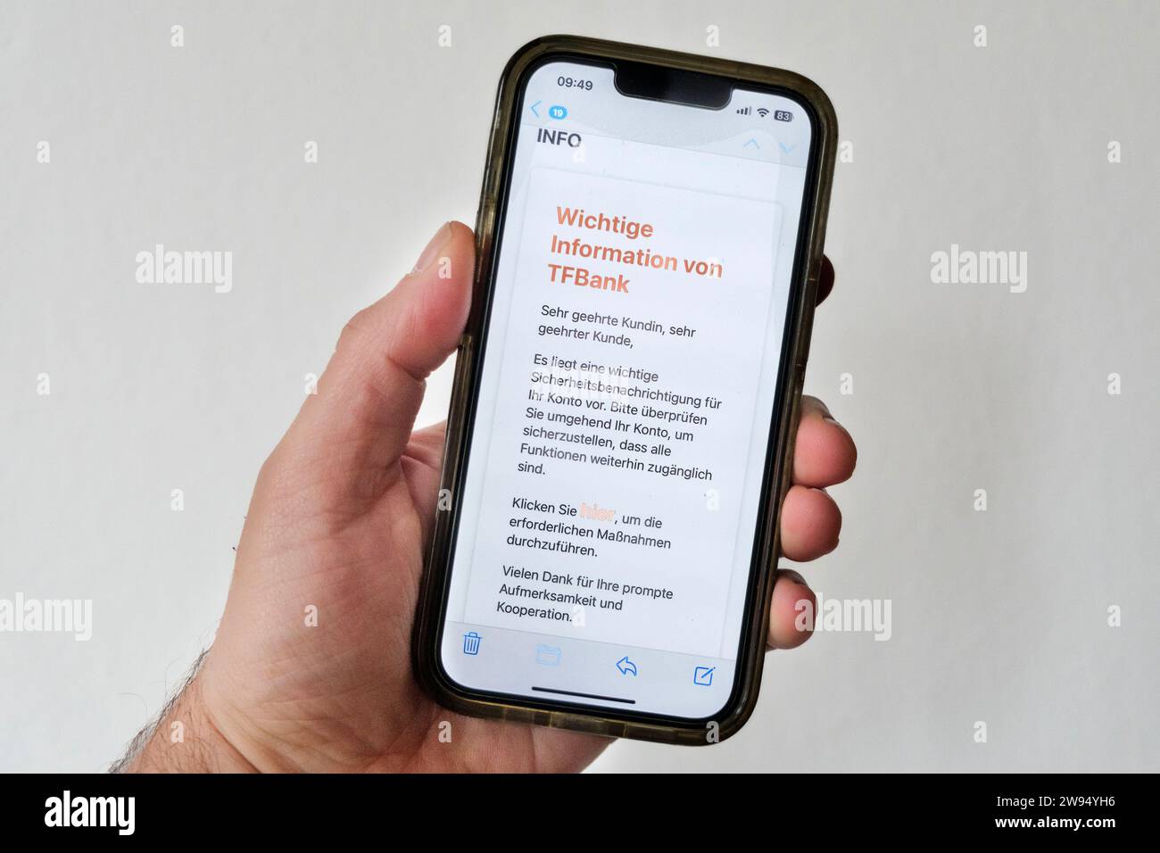 Mano che tiene in mano un telefono cellulare che mostra un tentativo di phishing tramite e-mail, qui una falsa e-mail della TF Bank svedese Foto Stock