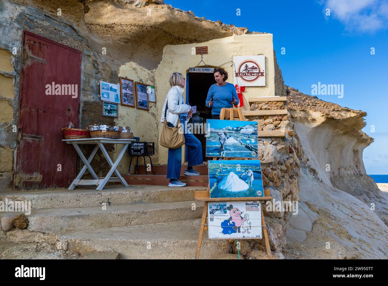 Josephine Xuereb all'ingresso della piccola salina sopra le saline di Gozo, Xwejni Bay. Negozio di sale Leli tal-Melh a Xwejni, vicino a Marsalforn, Gozo, Malta Foto Stock