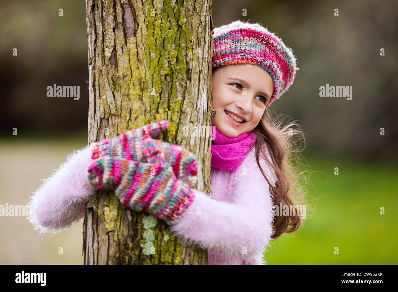 Bambina femmina che abbracciano un albero Foto Stock