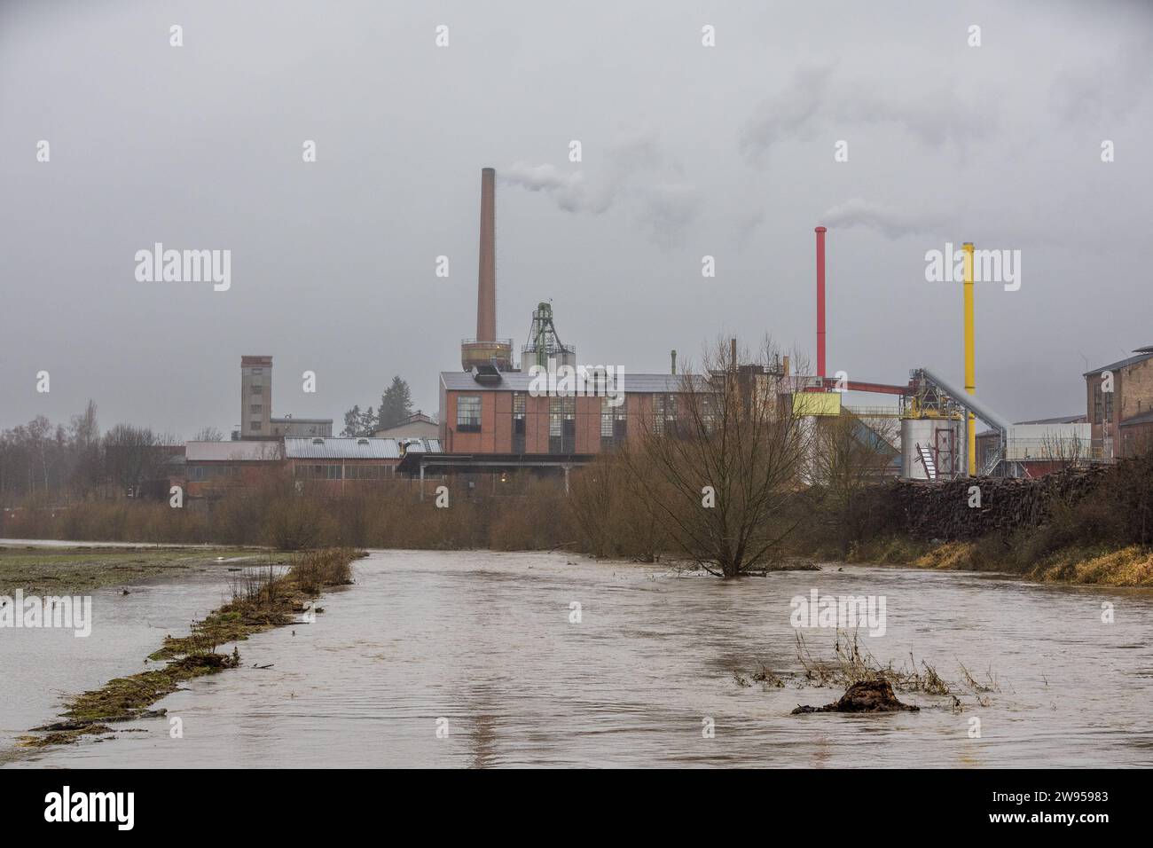 Hochwasser an der Weser im Grenzbereich zwischen Hessen und Niedersachsen, im Hintergrund die Fabrik der firma proFagus in Bodenfelde / Niedersachsen, 24. Dezember 2024, Wesertal-Lippooldsberg / Assia / Deutschland, foto: Karsten Socher fotografie / www.KS-FOTOGRAFIE.net - Fotograf in Kassel Foto Stock