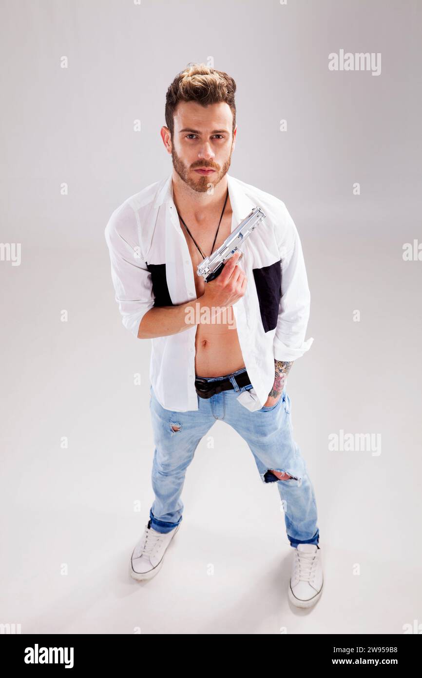 Giovane uomo potente con una pistola Foto Stock