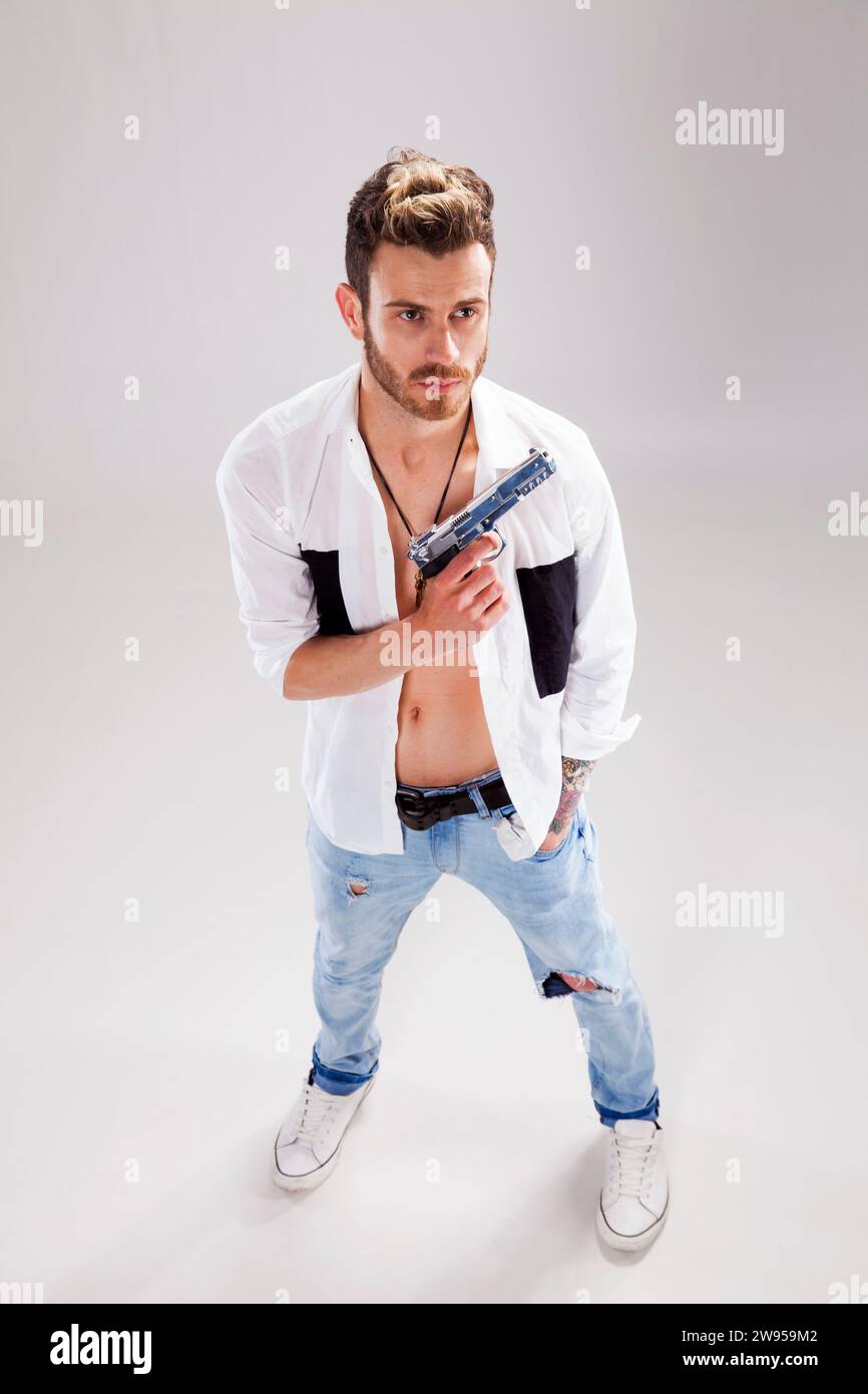 Giovane uomo potente con una pistola Foto Stock