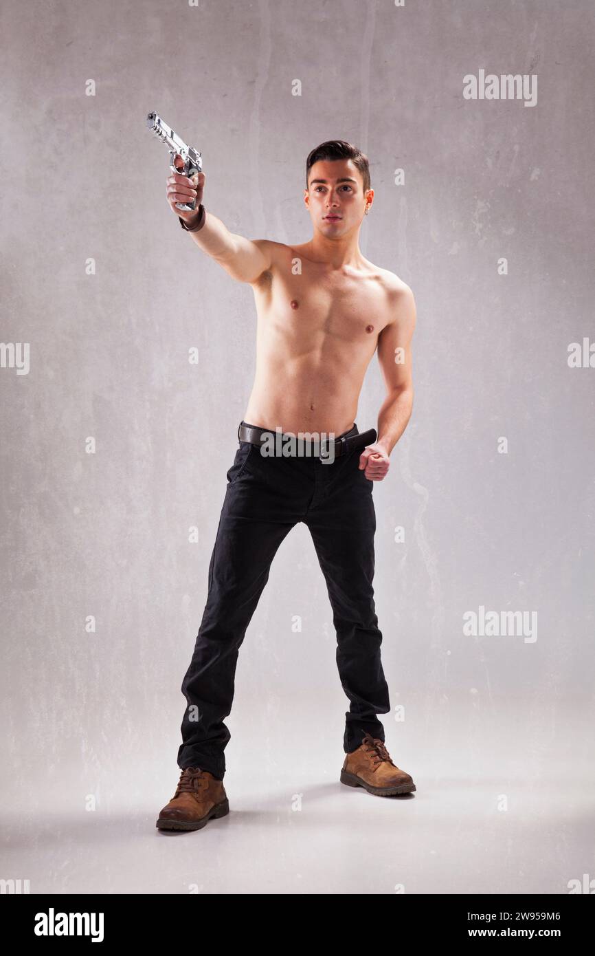 Giovane uomo potente con una pistola Foto Stock