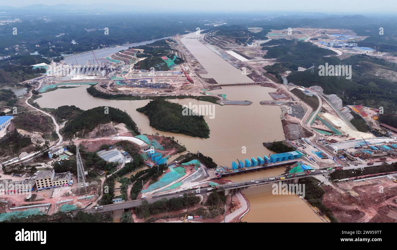 Qinzhou. 24 dicembre 2023. Questa foto aerea scattata il 24 dicembre 2023 mostra il sito di costruzione di un incrocio del canale di Pinglu nella regione autonoma del Guangxi Zhuang nel sud della Cina. Il Canale di Pinglu è un progetto di punta sul nuovo corridoio internazionale del commercio terrestre-marittimo. Si estende dal bacino idrico di Xijin nella città di Hengzhou al porto di Qinzhou nel sud del Guangxi, dove le navi possono raggiungere il Golfo di Beibu attraverso il fiume Qinjiang, aprendo una rotta più breve verso il mare per il Guangxi e altre regioni nel sud-ovest della Cina. Crediti: Zhang Ailin/Xinhua/Alamy Live News Foto Stock
