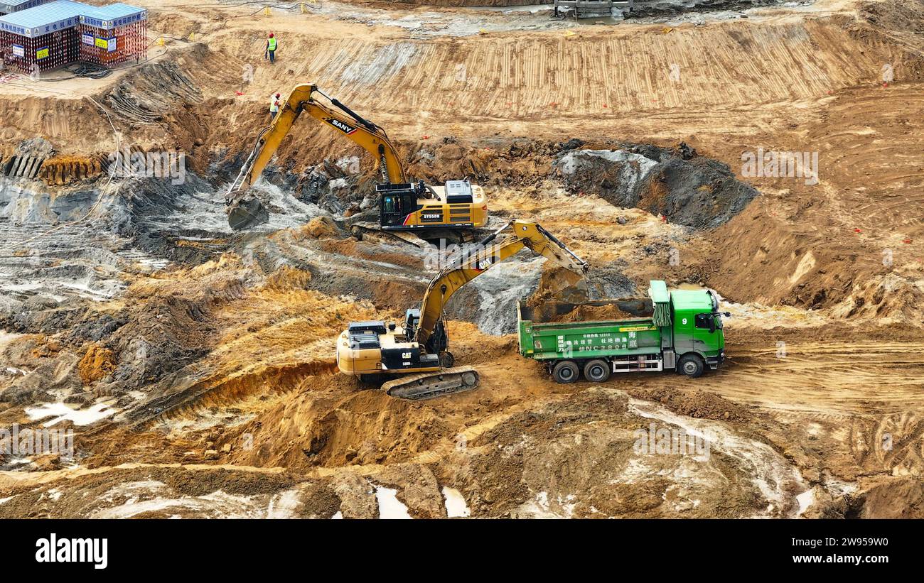 Qinzhou. 24 dicembre 2023. Questa foto aerea scattata il 24 dicembre 2023 mostra un team di costruzione che allarga il corso d'acqua a Qinzhou, nella regione autonoma del Guangxi Zhuang nel sud della Cina. Il Canale di Pinglu è un progetto di punta sul nuovo corridoio internazionale del commercio terrestre-marittimo. Si estende dal bacino idrico di Xijin nella città di Hengzhou al porto di Qinzhou nel sud del Guangxi, dove le navi possono raggiungere il Golfo di Beibu attraverso il fiume Qinjiang, aprendo una rotta più breve verso il mare per il Guangxi e altre regioni nel sud-ovest della Cina. Crediti: Zhang Ailin/Xinhua/Alamy Live News Foto Stock