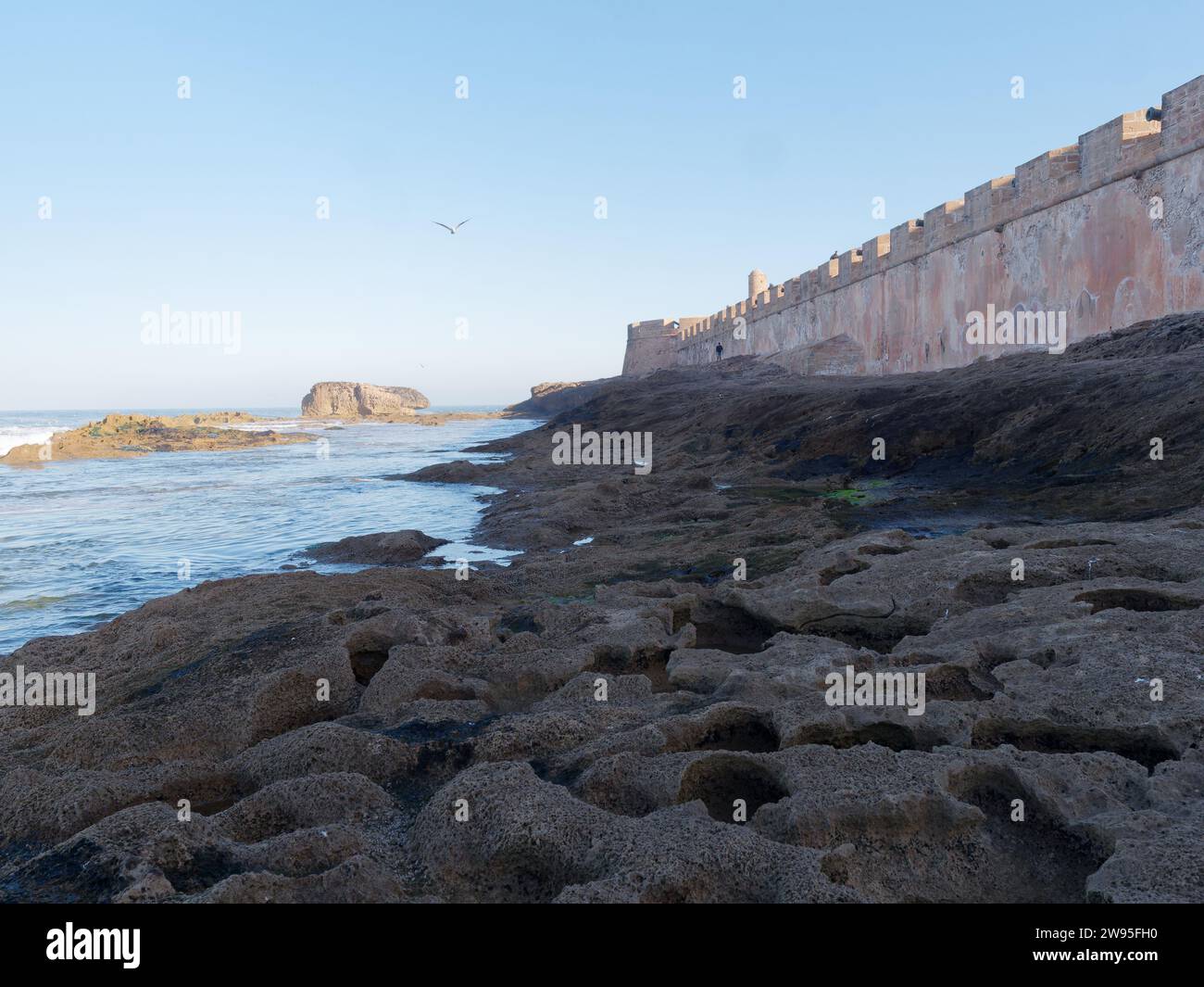Costa rocciosa con le mura della Medina a Essaouira, Marocco. 23 dicembre 2023 Foto Stock