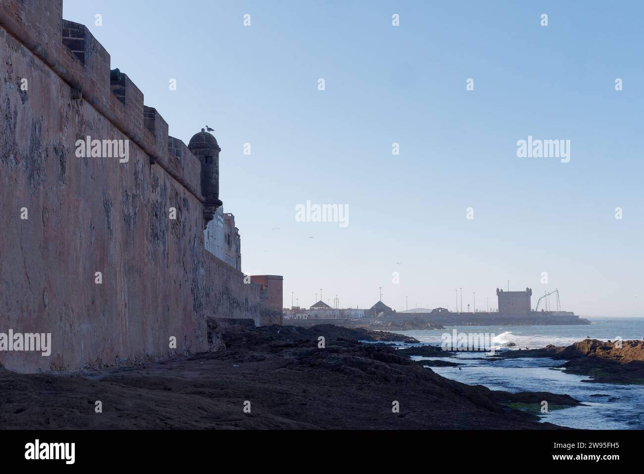 Costa rocciosa con le mura della Medina a Essaouira, Marocco. 23 dicembre 2023 Foto Stock