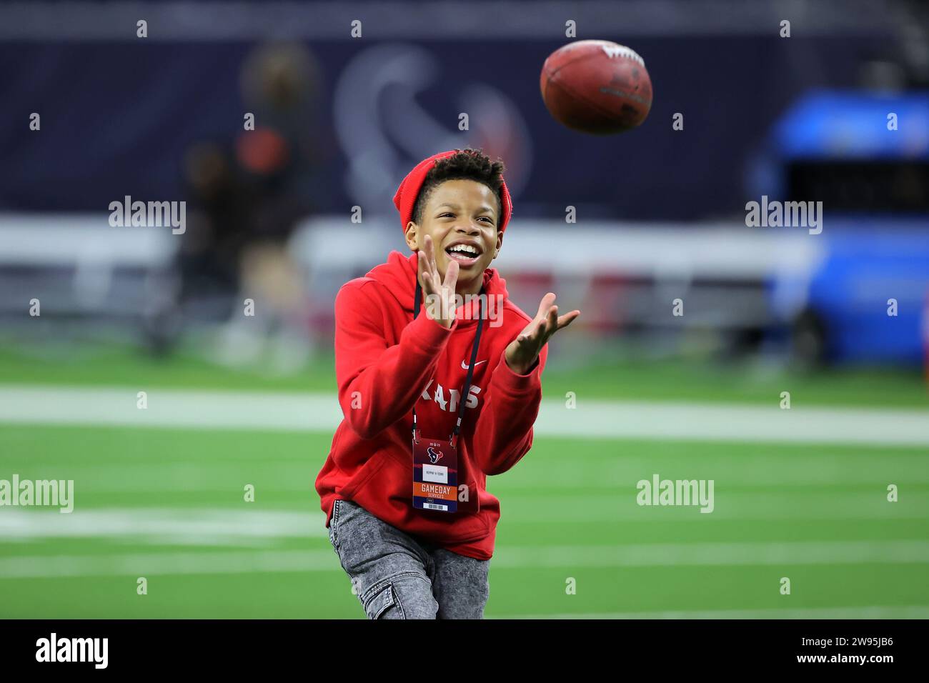 Houston, Texas, Stati Uniti. 24 dicembre 2023. Un giovane tifoso degli Houston Texans prese una partita di football in campo prima della partita tra gli Houston Texans e i Cleveland Browns all'NRG Stadium di Houston, Texas, il 24 dicembre 2023. (Immagine di credito: © Erik Williams/ZUMA Press Wire) SOLO USO EDITORIALE! Non per USO commerciale! Foto Stock