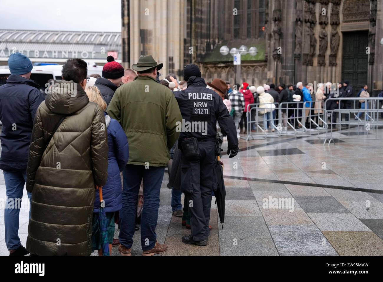 Polizeiliche Sicherheitsmassnahmen am Koelner Dom vor dem Gottesdienst Teilnehmer und Besucher Warten am Eingang des Koelner Dom bei erhoehten Siecherheitsmassnahmen vor dem Gottesdienst und der Messe am Heiligabend, Koeln, 24.12.2023 Koeln Nordrhein-Westfalen Deutschland *** misure di sicurezza della polizia nella Cattedrale di Colonia prima del servizio partecipanti e visitatori attendono all'ingresso della Cattedrale di Colonia durante le misure di sicurezza aumentate prima del servizio e della messa la vigilia di Natale, Colonia, 24 12 2023 Colonia Renania settentrionale-Vestfalia Germania Foto Stock