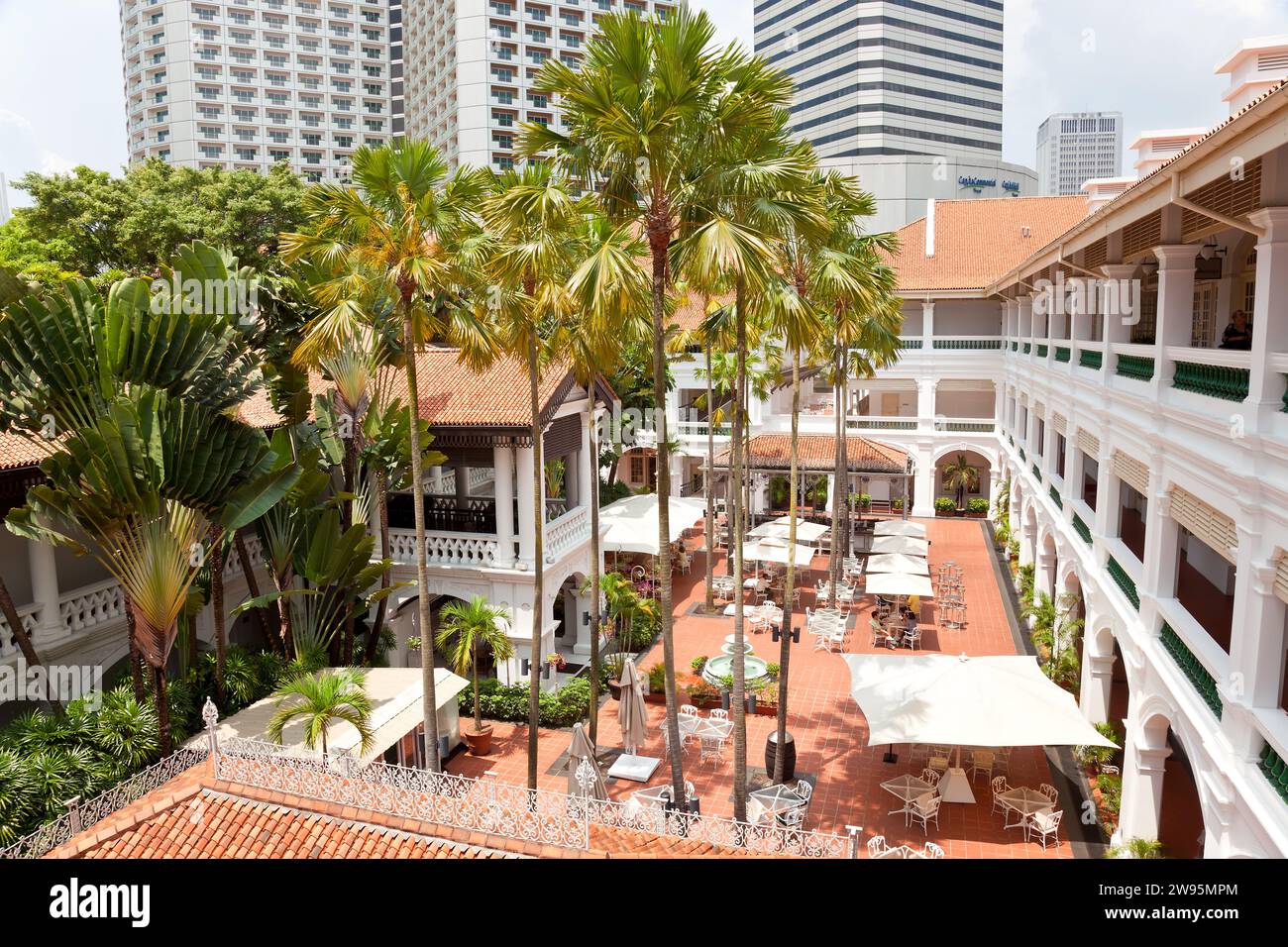 Un cortile nel Raffles Hotel, Singapore, Sud Est Asiatico. Inaugurato nel 1899, prende il nome dal fondatore di Singapore, Sir Stamford Raffles. Uno stile coloniale Foto Stock