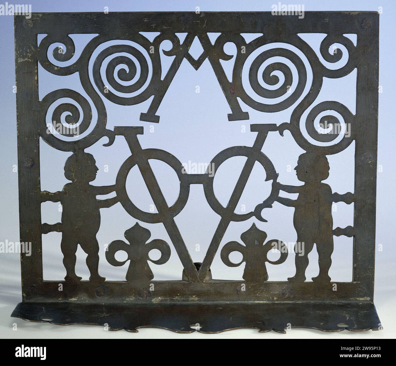 Minore, anonimo, 1700 - 1800 minore sotto forma di lastra di apertura rettangolare in cui due figure indossano le lettere dell'iscrizione tra le decorazioni; sotto una lastra di supporto orizzontale con bordo graziosamente tagliato. Lo standard è un'asta di ferro tonda, piegata due volte con un angolo retto, che cade in un anello sul retro della scrivania. Amsterdam rame (metallo). Ferro (metallo) forgiato figura in piedi Amsterdam Foto Stock