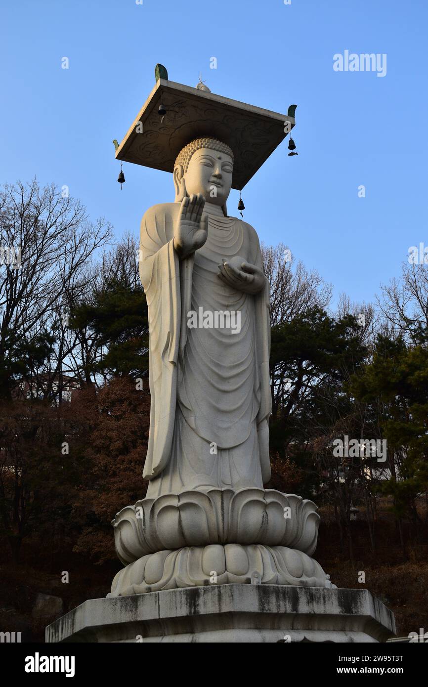 Grande statua di Buddha in pietra al tempio Bongeunsa nel cuore del quartiere Gangnam Foto Stock