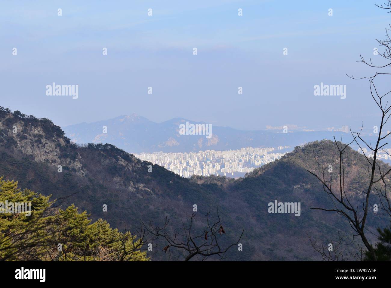 Vista panoramica delle aree urbane di Seoul, vista dalle cime delle montagne sui sentieri escursionistici del Parco Nazionale di Bukhansan Foto Stock