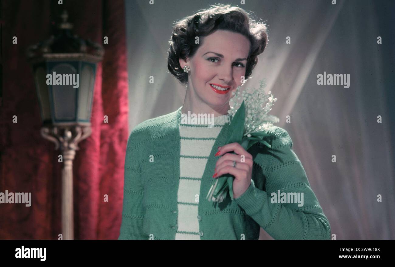 Anni '1950, storico, rosa inglese, moda femminile dell'epoca, una giovane donna che indossa morbido color verde chiaro, cardigan di lana e top in lana a righe, Inghilterra, Regno Unito. Foto Stock