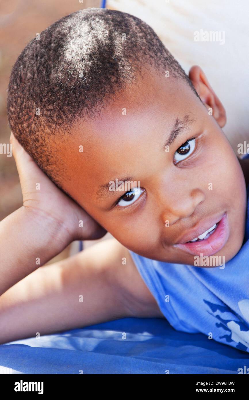 bambino africano nel villaggio riposa all'aperto nel cortile Foto Stock